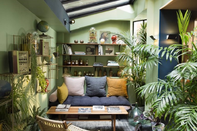 Paredes verdes e decorações que aludem a natureza em sala de estar Urban Jungle